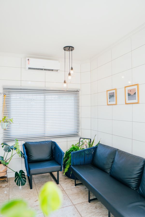 Sala de espera com sofás azuis e plantas